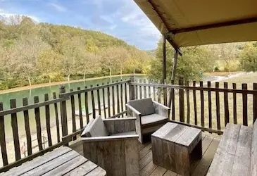 Vue sur le lac du camping depuis la terrasse d'une tente lodge